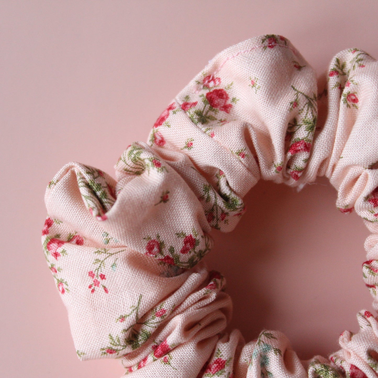 Pale pink scrunchie with subtle red small flowers