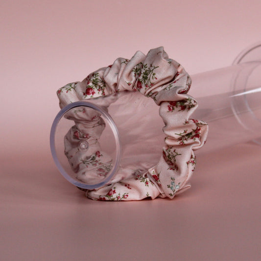 Pale pink scrunchie with subtle red small flowers