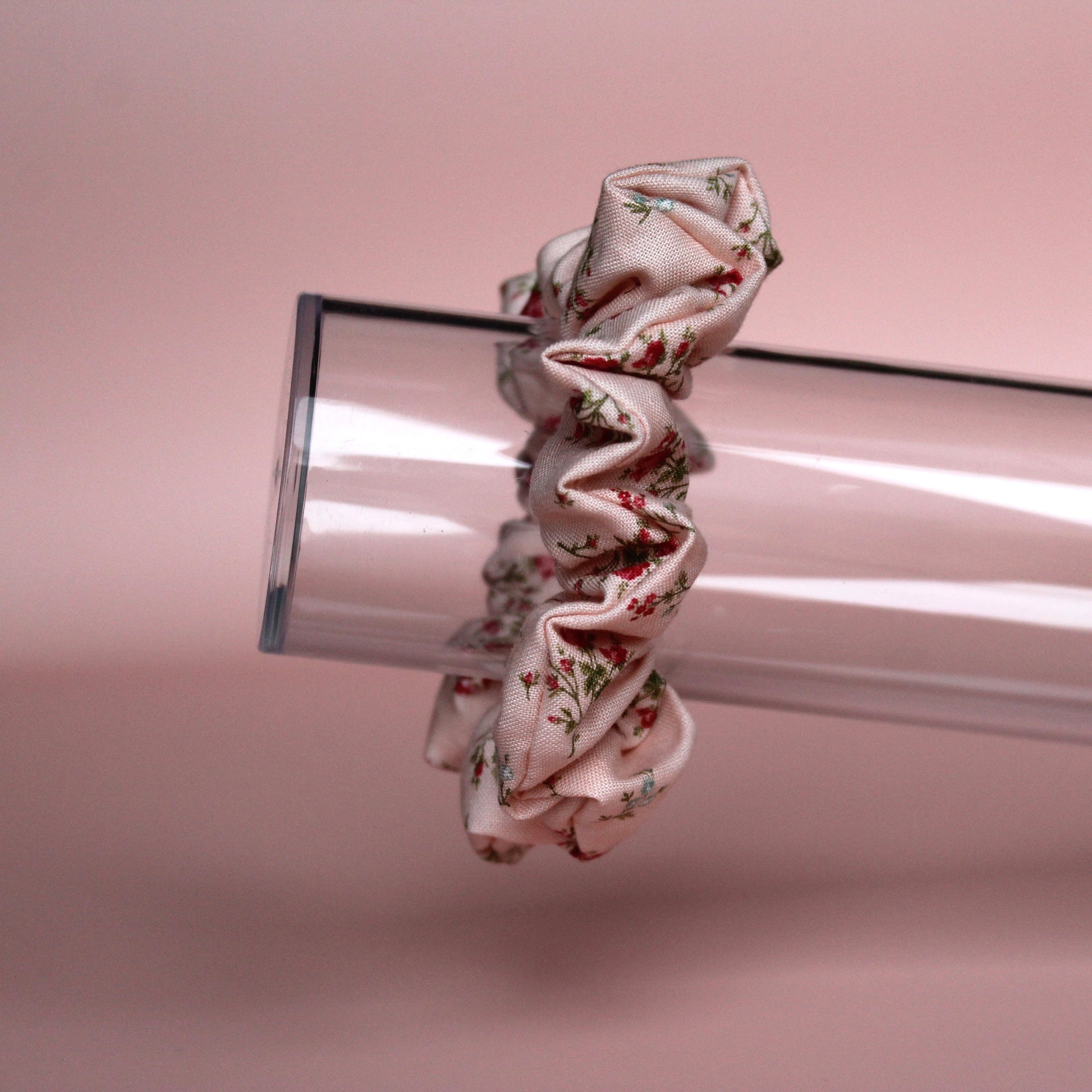 Pale pink scrunchie with subtle red small flowers