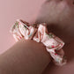 Pale pink scrunchie with subtle red small flowers