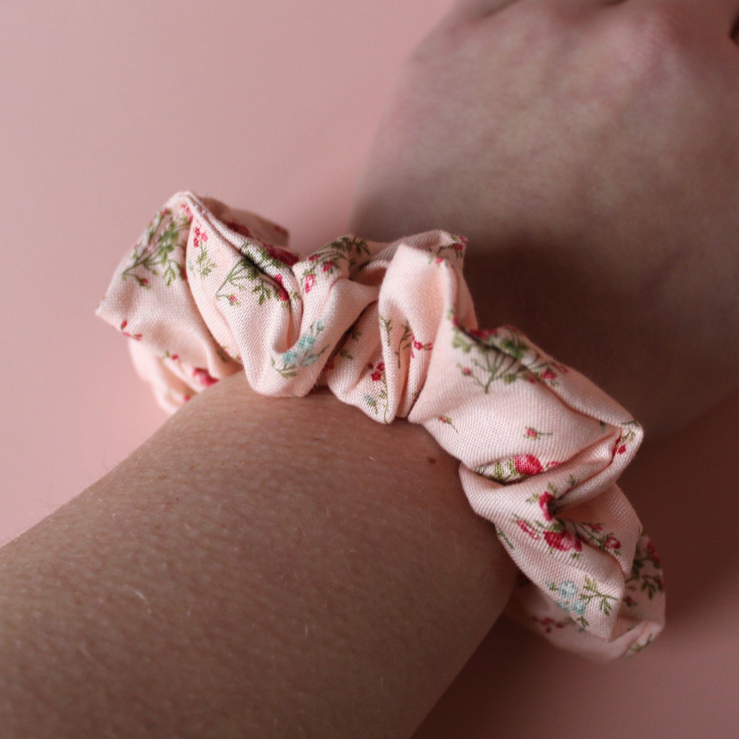 Pale pink scrunchie with subtle red small flowers