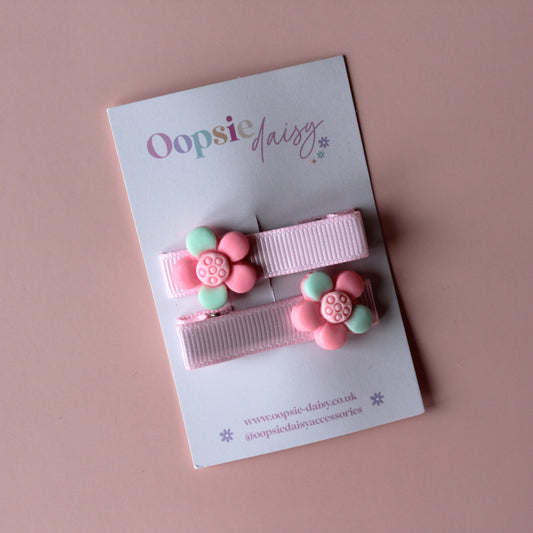 Pink pastel hair clips with pink and green flower embellishment