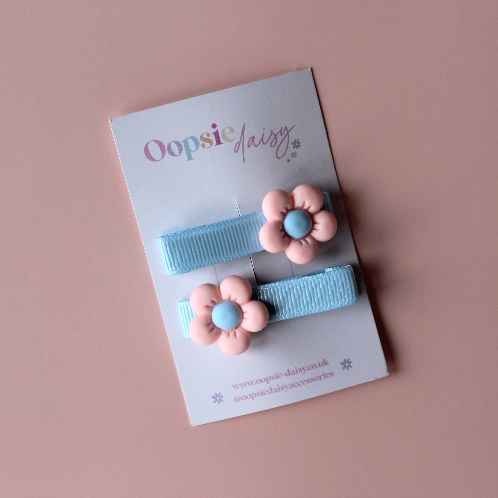 Blue pastel hair clips with pink and blue flower embellishment