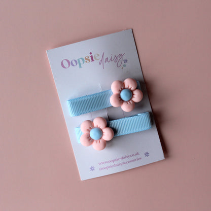 Blue pastel hair clips with pink and blue flower embellishment