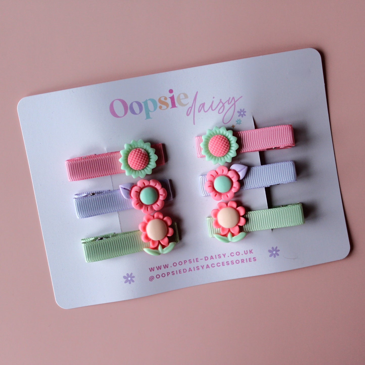 Pastel hair sliders with flower embellishments in purple, peachy-pink and green