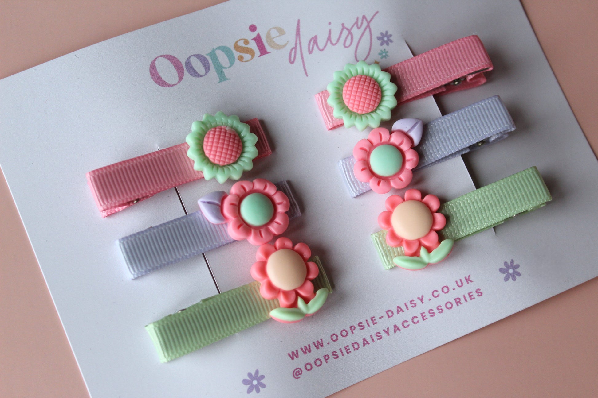 Pastel hair sliders with flower embellishments in purple, peachy-pink and green