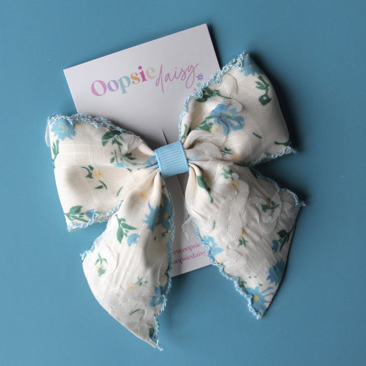 Off-white hair bow with light blue little flowers and light blue trim