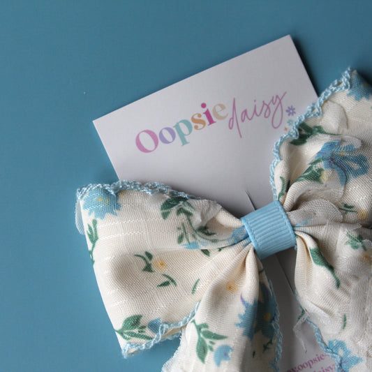 Off-white hair bow with light blue little flowers and light blue trim