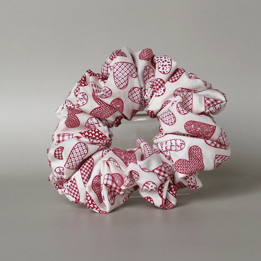 Oversized hair scrunchie with red heart pattern on neutral off-white background
