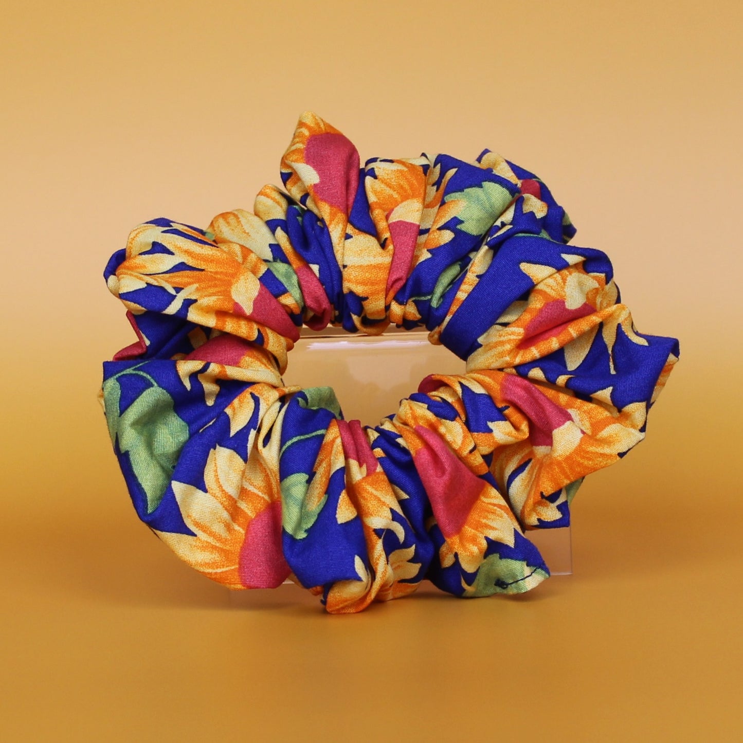 Oversized blue scrunchie with bold yellow and orange sunflowers
