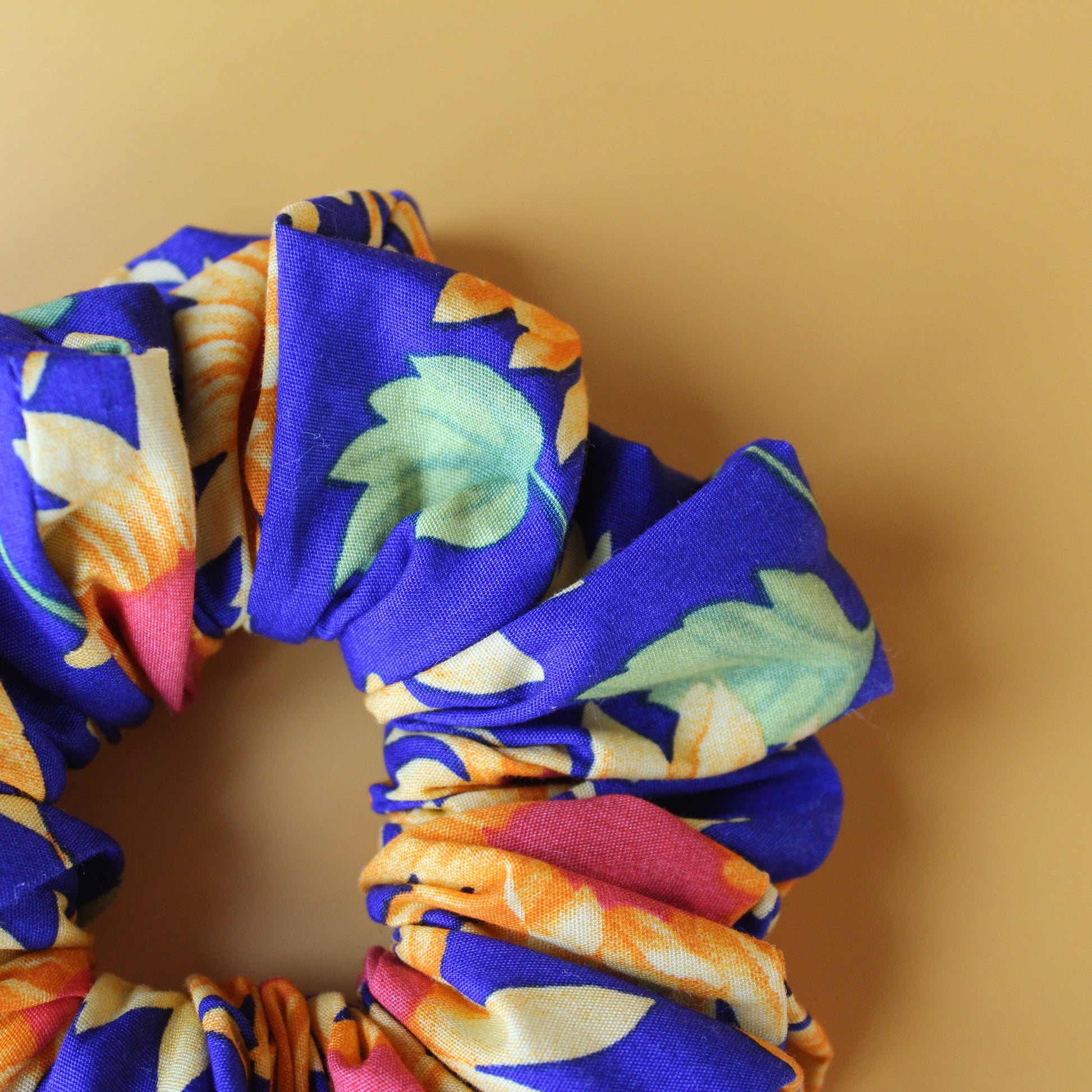 Oversized blue scrunchie with bold yellow and orange sunflowers