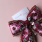 Deep red hair bow with embroidered floral pattern and sequins in gold, light pink and green