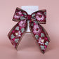 Deep red hair bow with embroidered floral pattern and sequins in gold, light pink and green