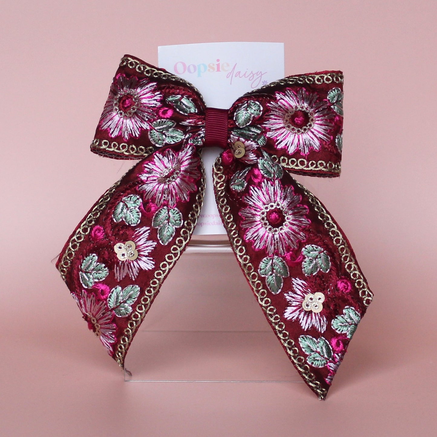 Deep red hair bow with embroidered floral pattern and sequins in gold, light pink and green