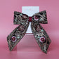 Black hair bow with gold and burgundy embroidered floral pattern