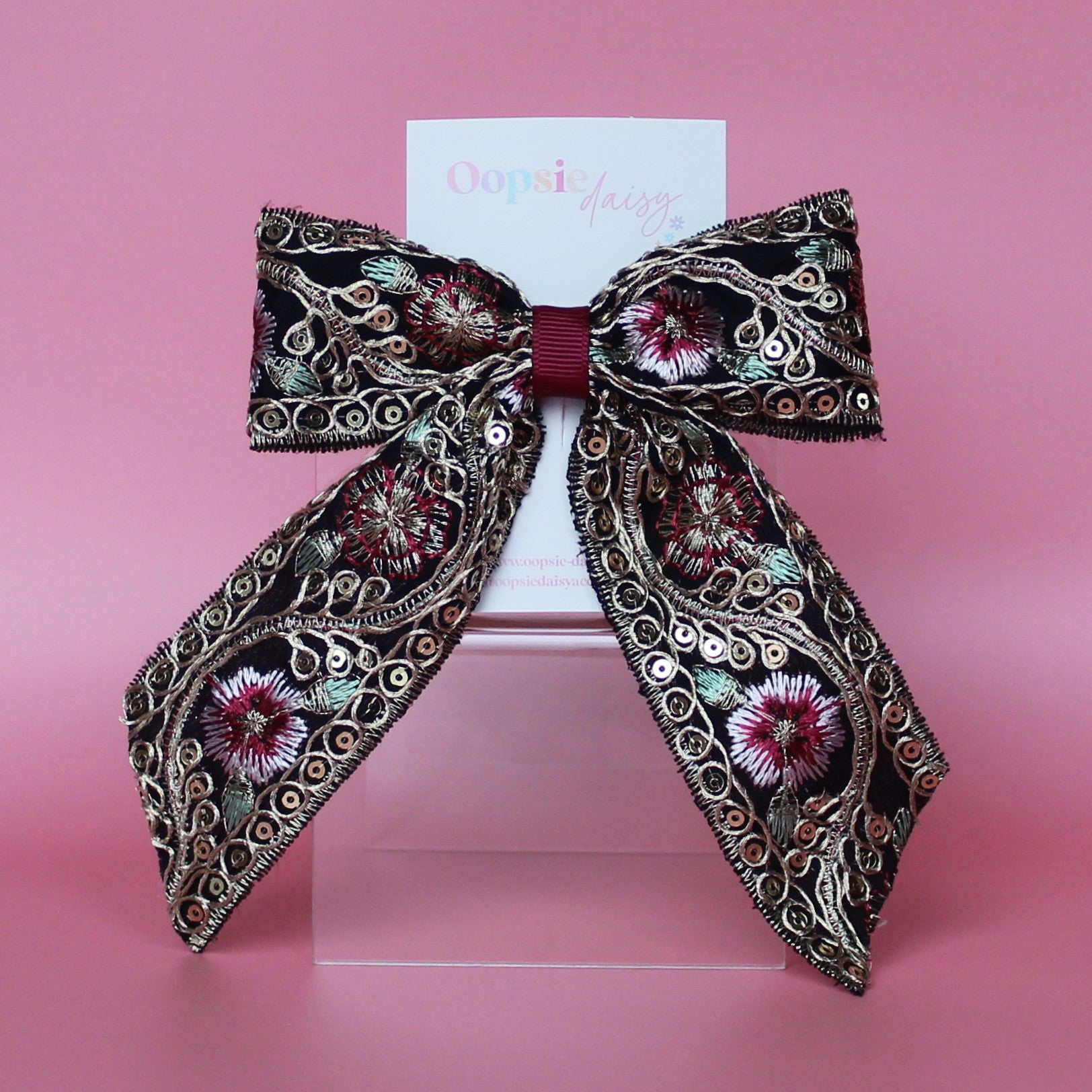 Black hair bow with gold and burgundy embroidered floral pattern