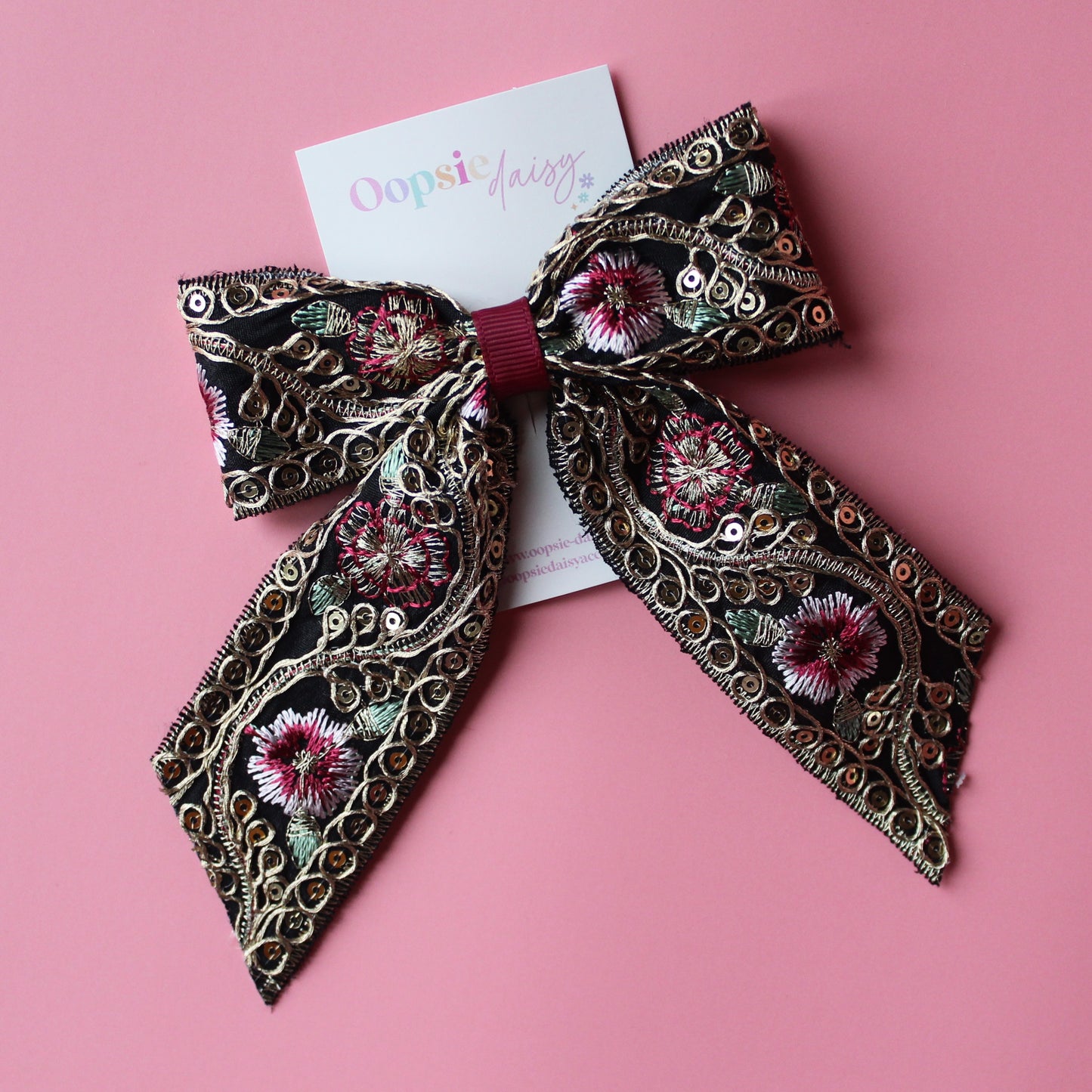Black hair bow with gold and burgundy embroidered floral pattern