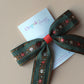 Khaki hair bow with rust orange and cream floral pattern