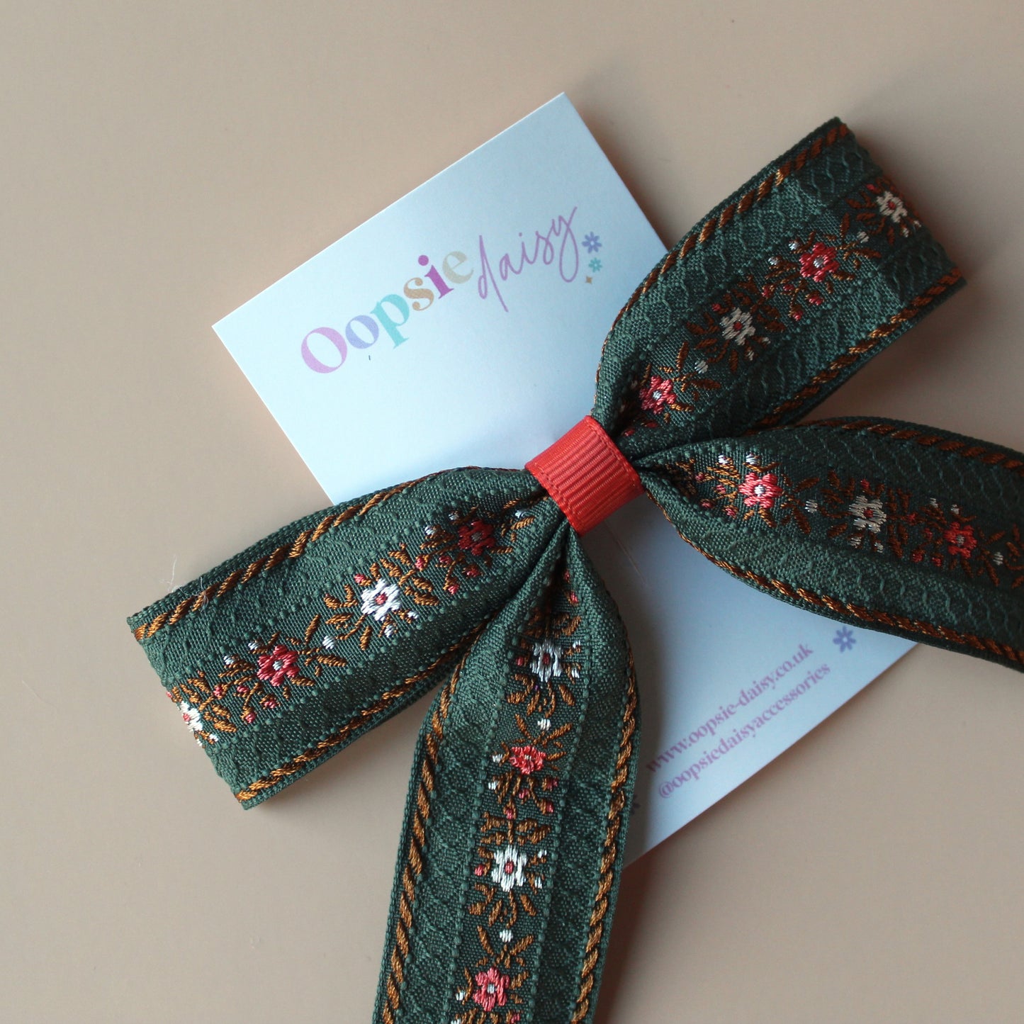 Khaki hair bow with rust orange and cream floral pattern