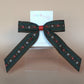 Khaki hair bow with rust orange and cream floral pattern