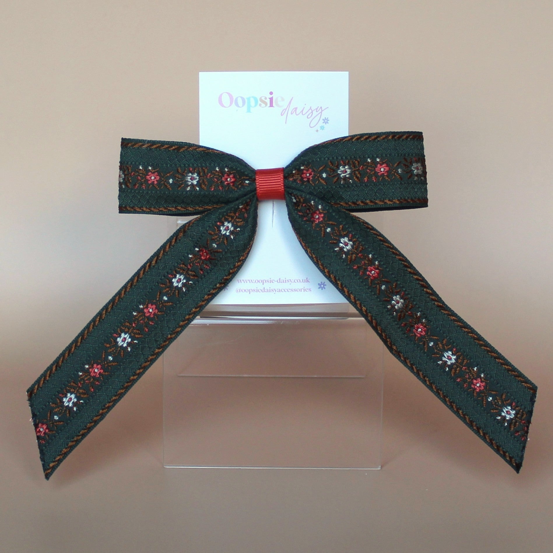 Khaki hair bow with rust orange and cream floral pattern