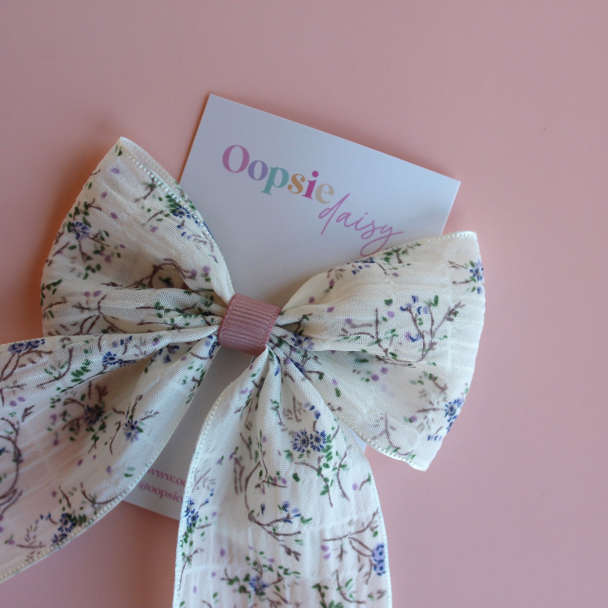 Cream hair bow with little muted mauve-purple flowers