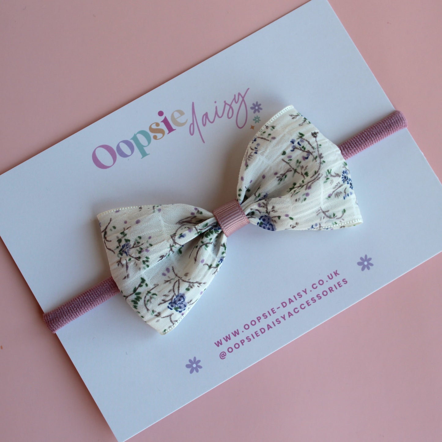 Cream hair bow on baby headband with little muted mauve-purple flowers