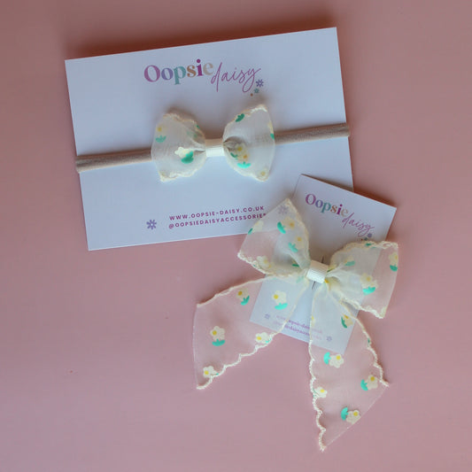 Gift set of baby headband and hair bow with cream sheer fabric with small dainty cream and green flowers.