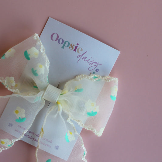 Sheer cream hair bow with dainty yellow-cream and green flowers