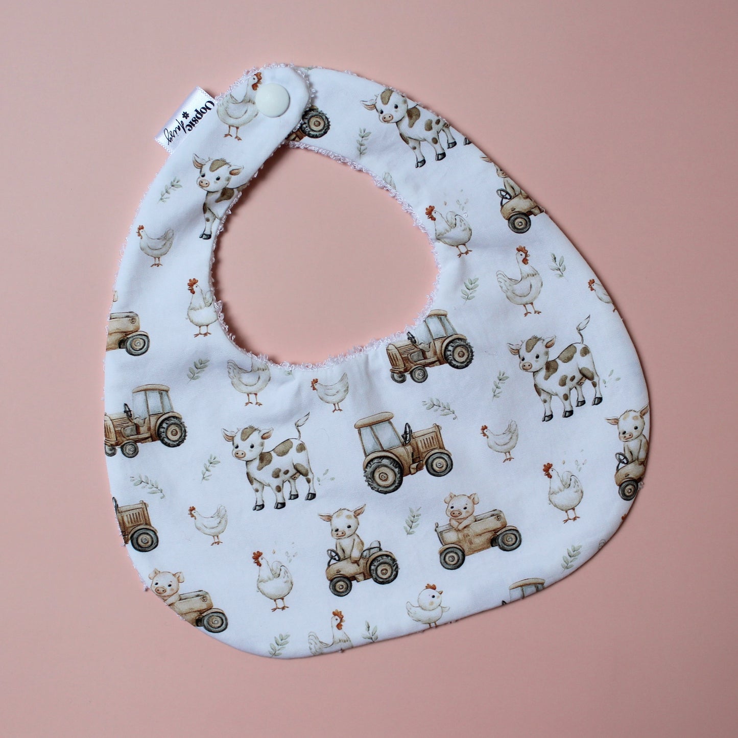 Baby bib with farm design of tractors, chickens and cows