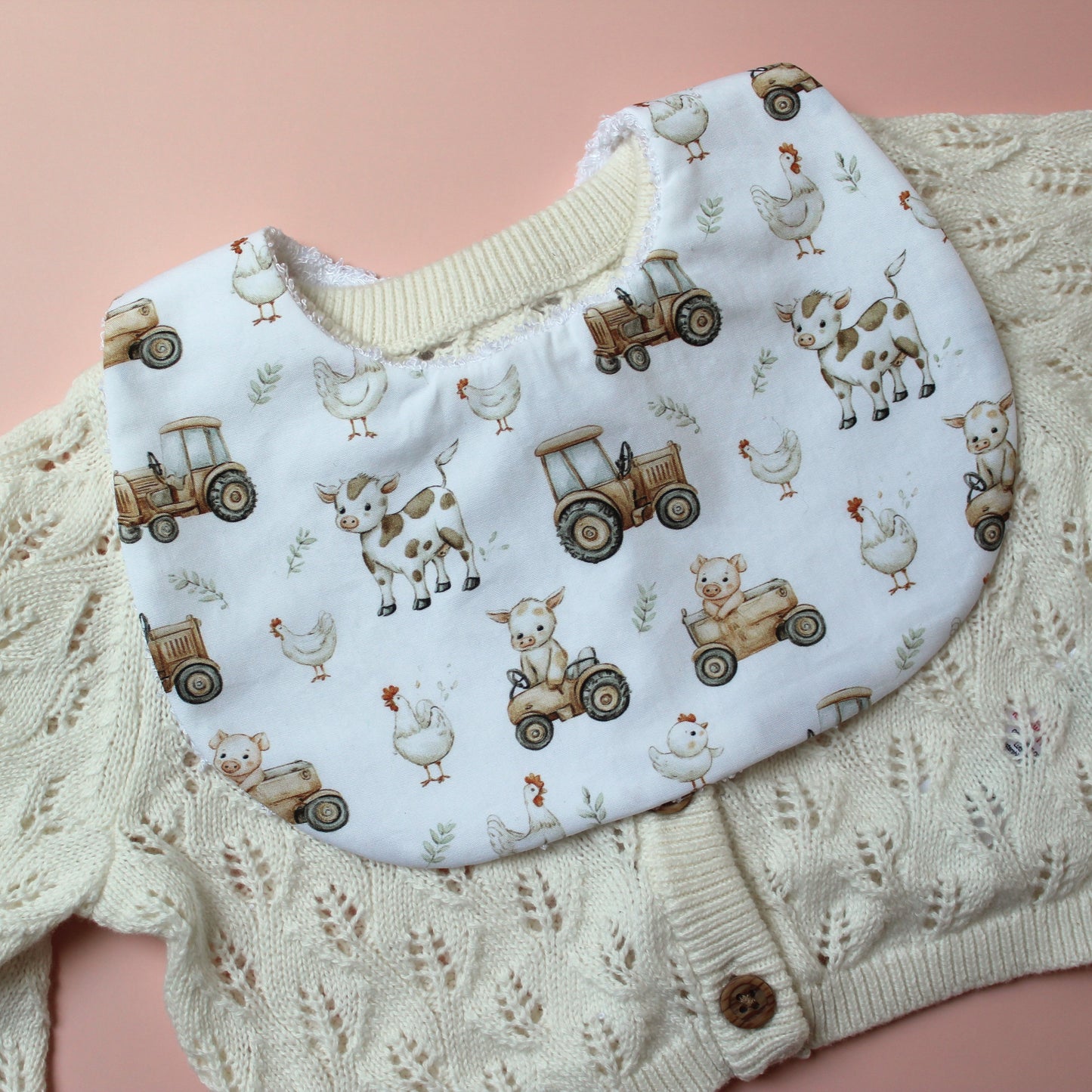 Baby bib with farm design of tractors, chickens and cows
