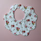 Scallop baby bib in cream with red/ yellow flower pattern