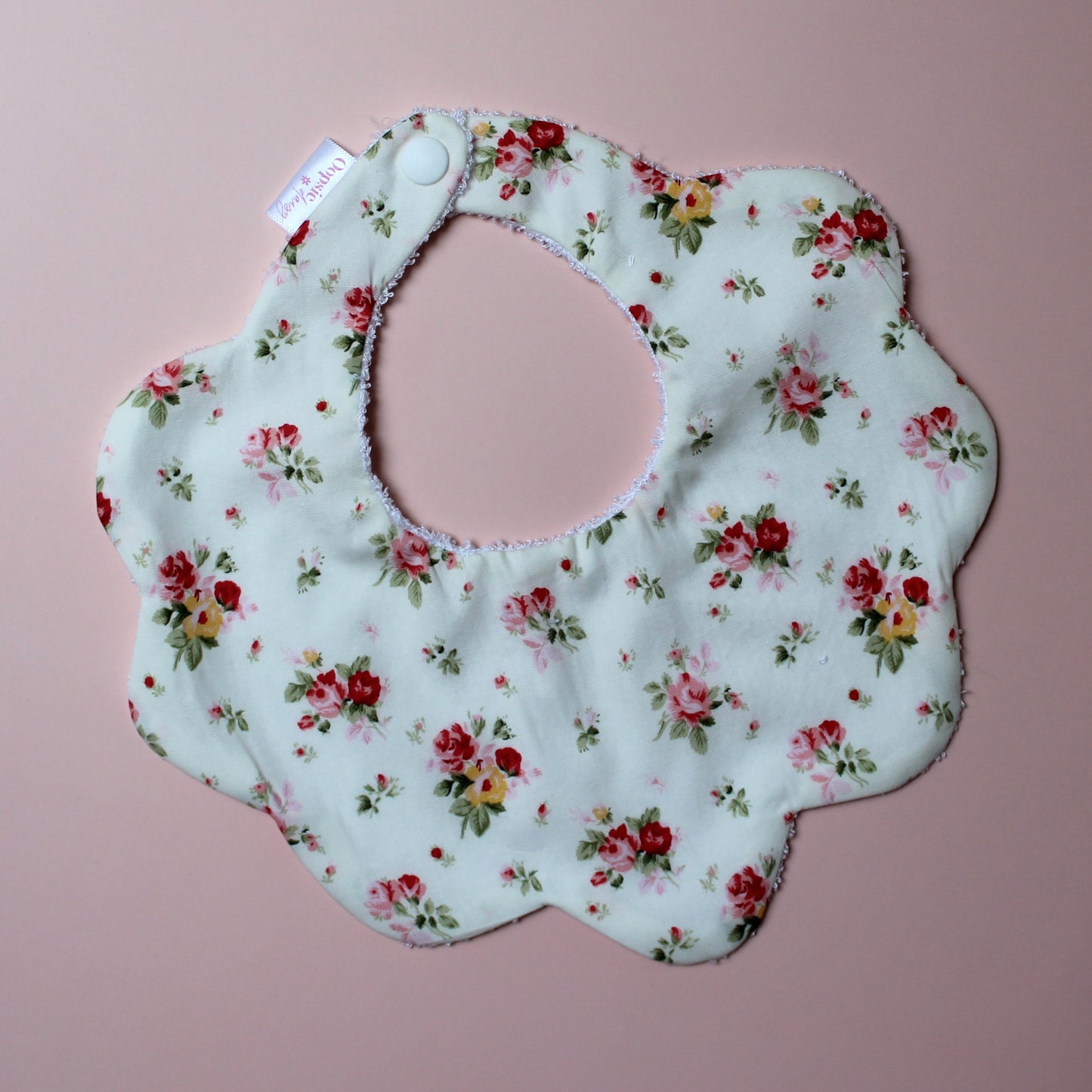 Scallop baby bib in cream with red/ yellow flower pattern