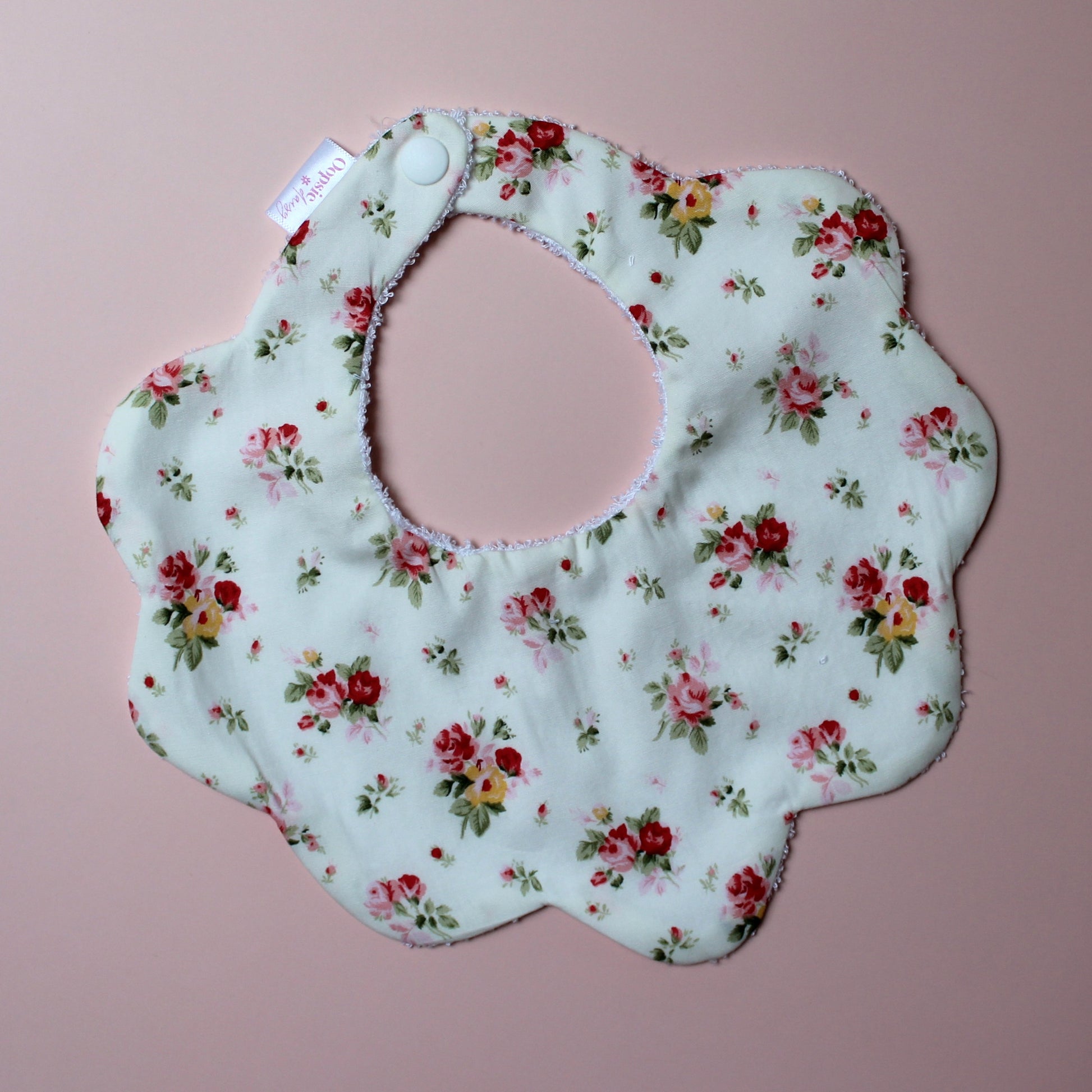 Scallop baby bib in cream with red/ yellow flower pattern