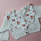 Scallop baby bib in cream with red/ yellow flower pattern