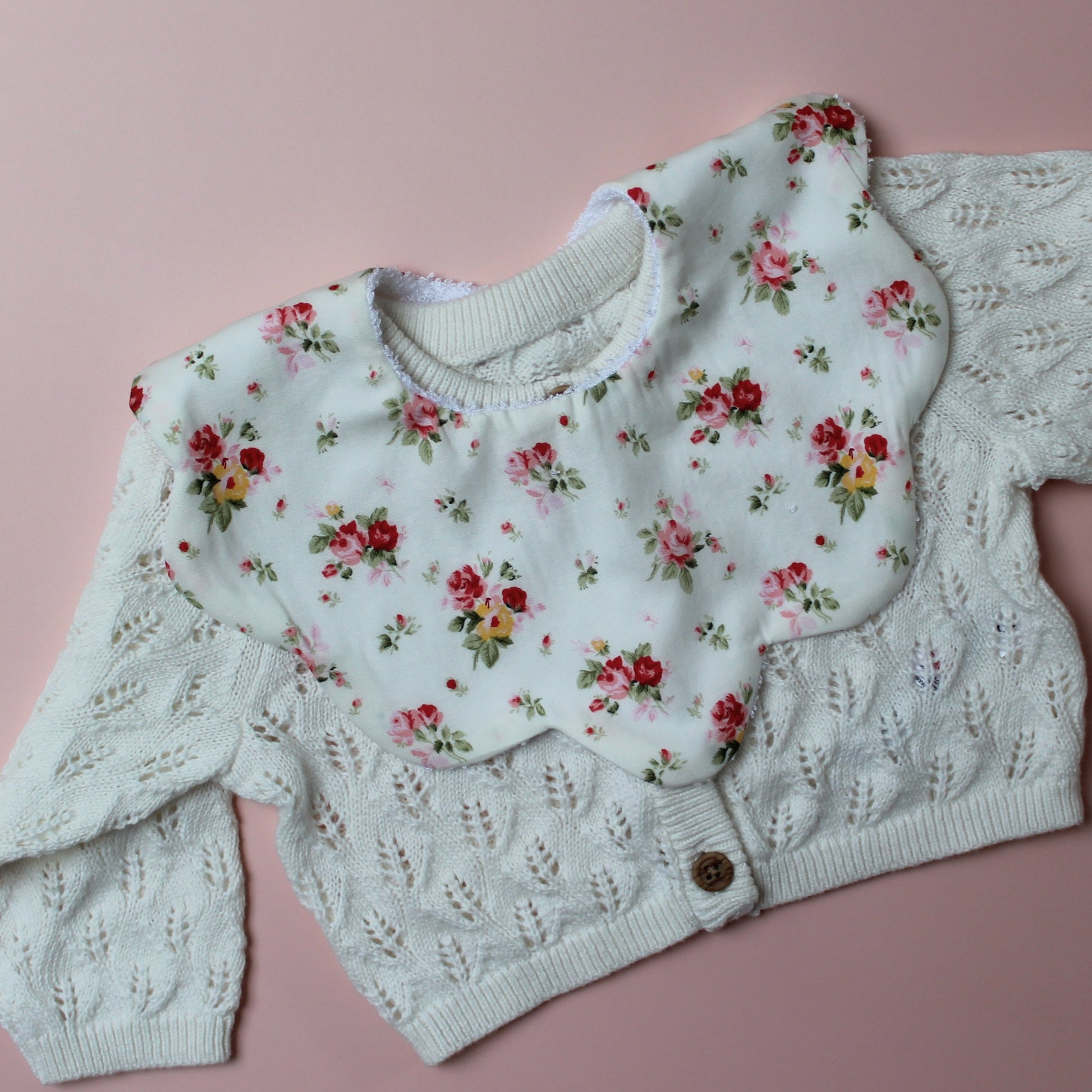 Scallop baby bib in cream with red/ yellow flower pattern