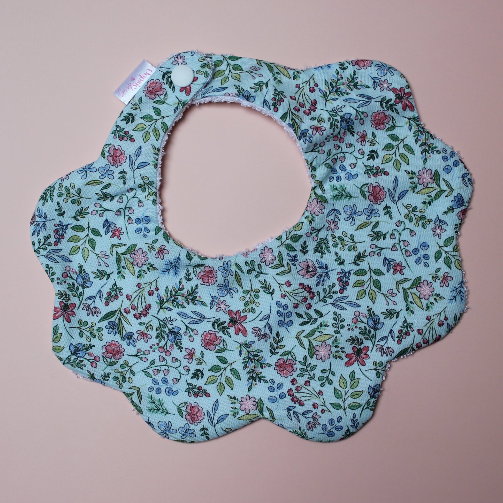 Blue scallop baby bib with ditsy floral pattern