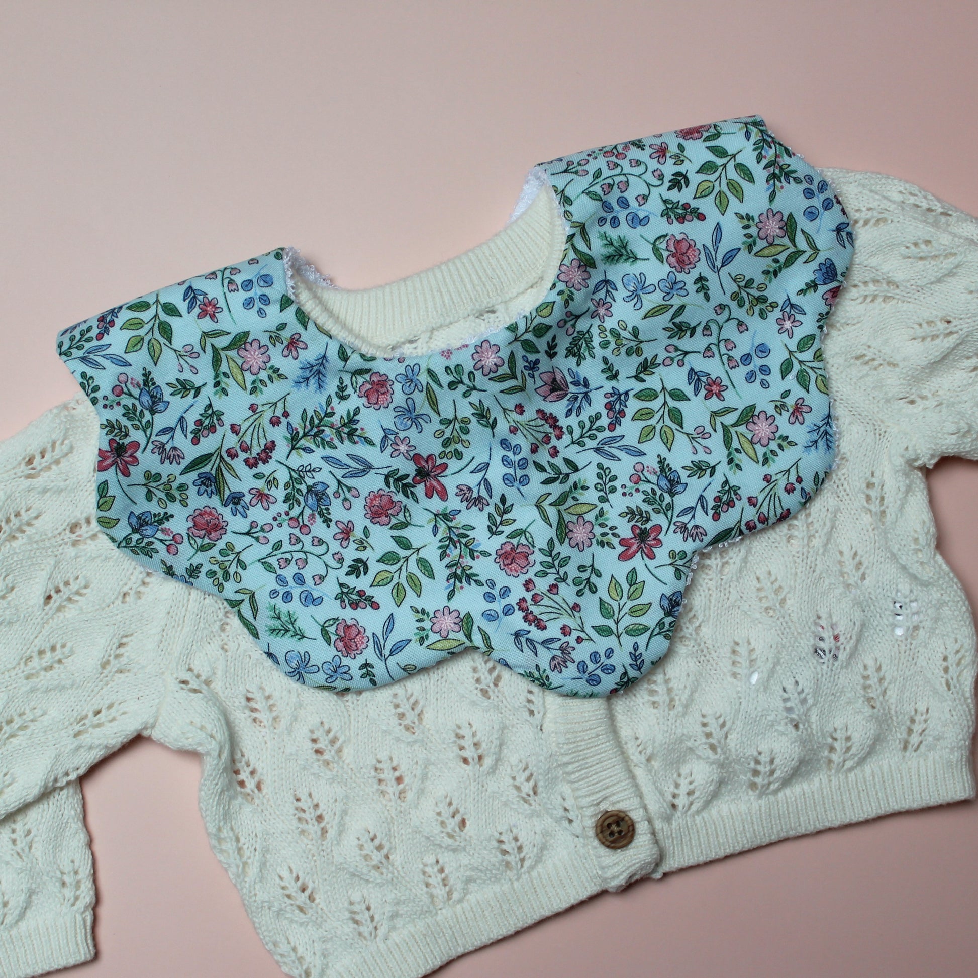 Blue scallop baby bib with ditsy floral pattern
