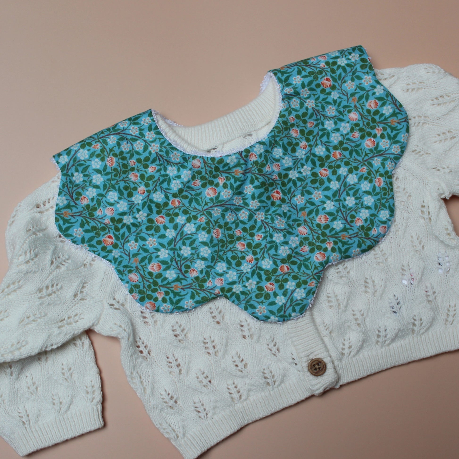 Scallop baby bib in teal with small ditsy flowers