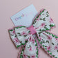 Cream hair bow with pink flowers and pink and green edges