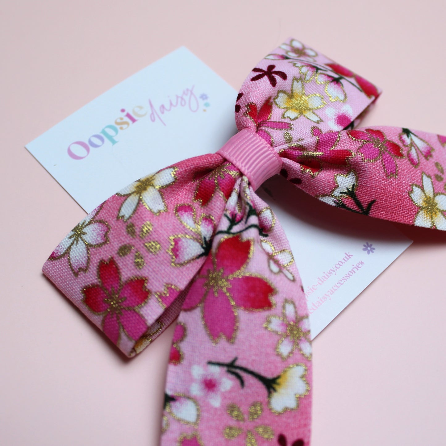 Pink and white ombre hair bow with flowers edged in gold shimmer 