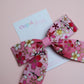Pink and white ombre hair bow with flowers edged in gold shimmer 