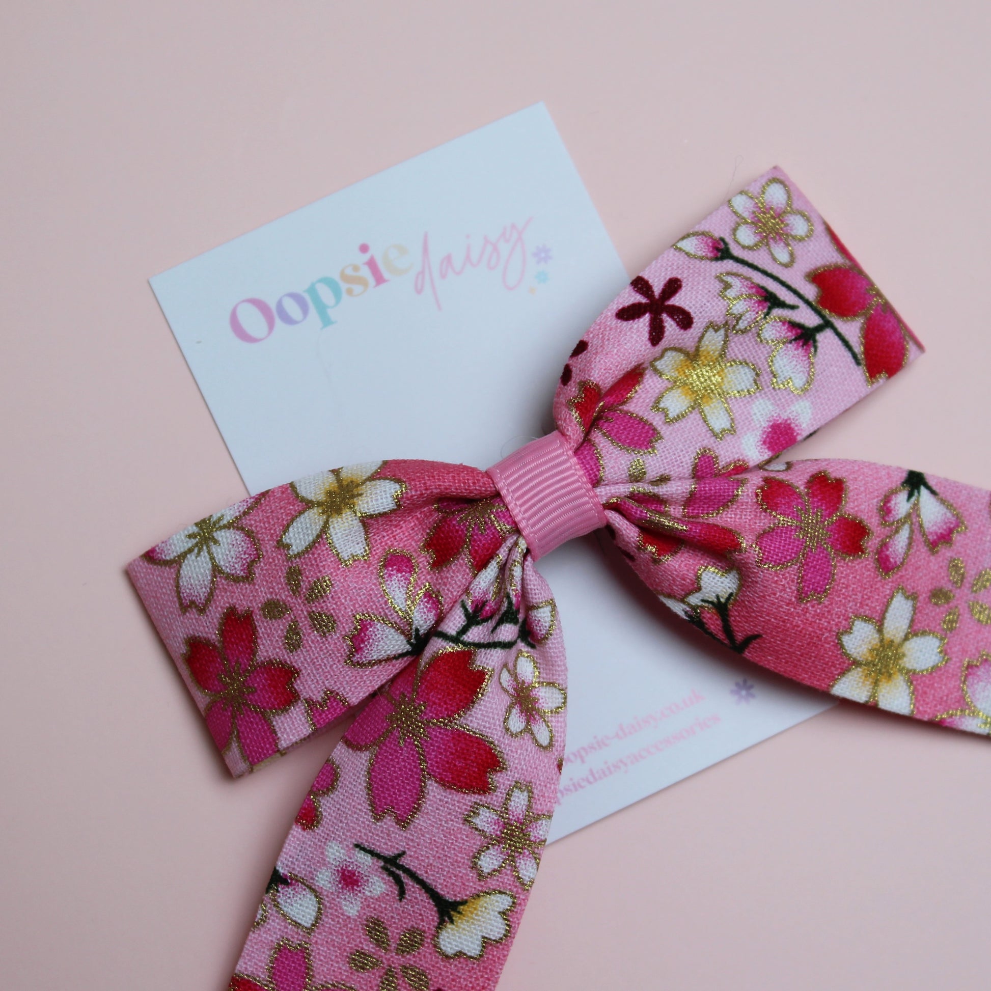 Pink and white ombre hair bow with flowers edged in gold shimmer 