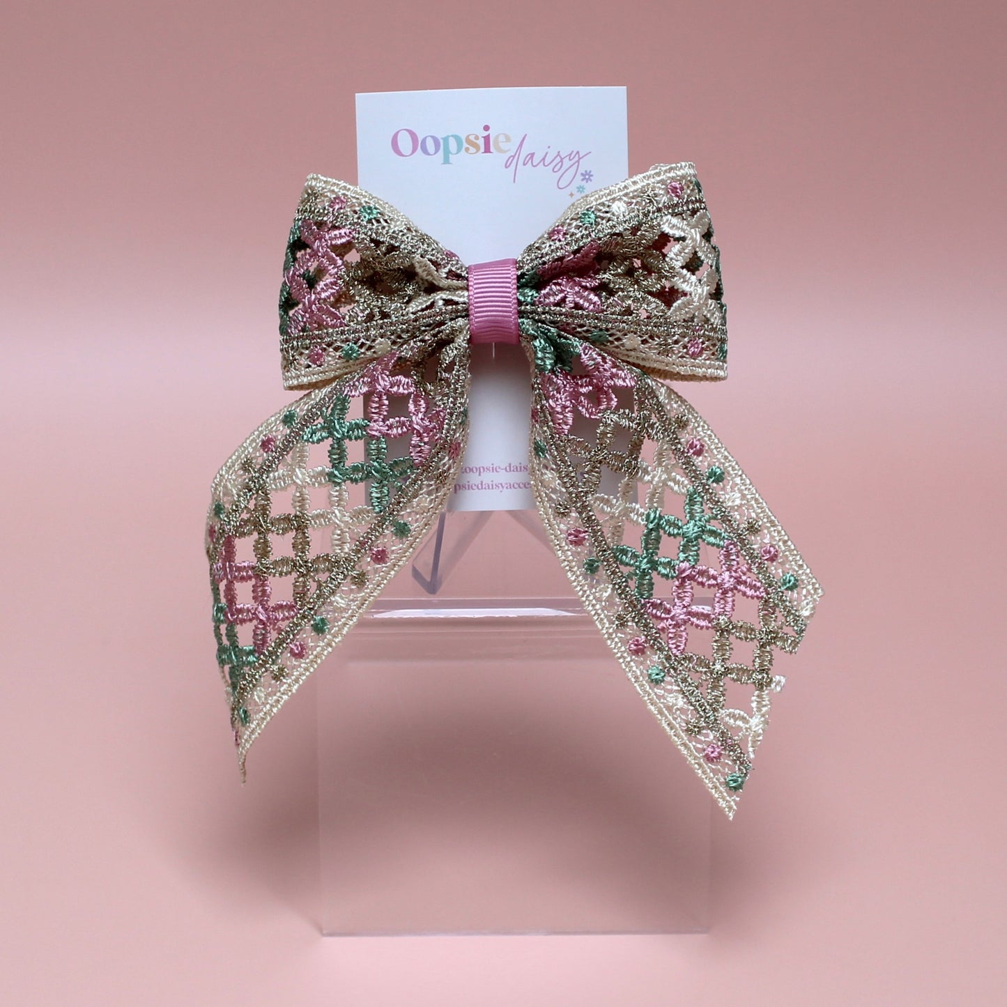 Hair bow with pink, green and gold shimmer embroidered crisscross pattern