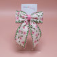 Cream hair bow with pink flowers and pink and green edges