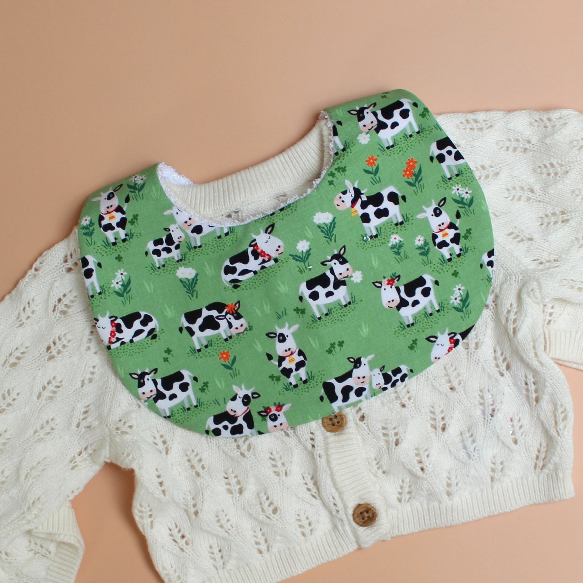 Baby bib with green background and  black and white cow pattern