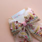 Transparent hair bow with colourful burgundy and gold embroidered floral pattern