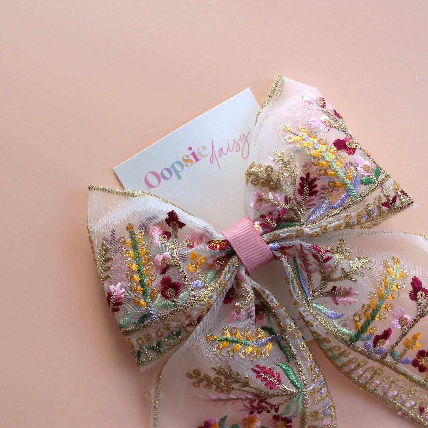 Transparent hair bow with colourful burgundy and gold embroidered floral pattern