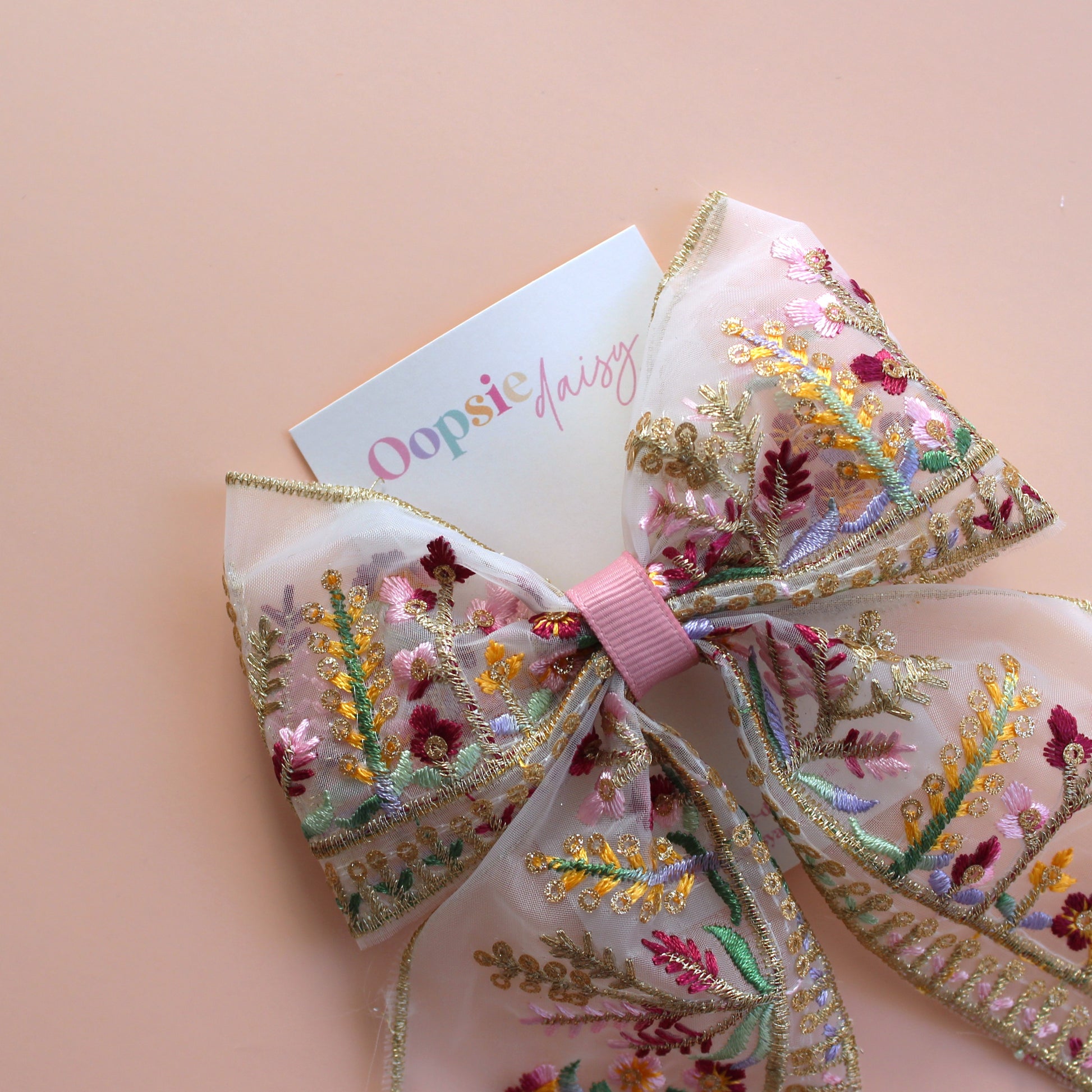 Transparent hair bow with colourful burgundy and gold embroidered floral pattern