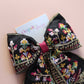 Black hair bow with colourful burgundy and gold embroidered floral pattern